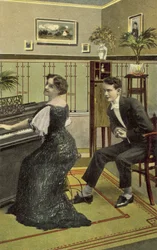 Young man admiring pretty girl playing the piano